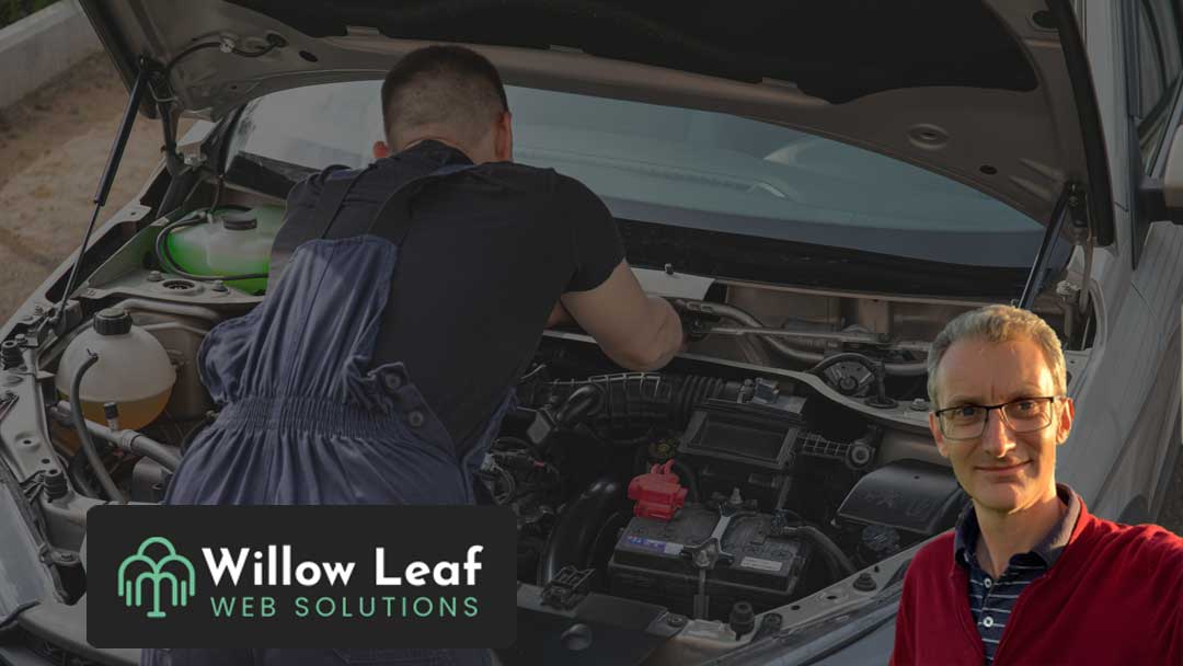 A mechanic leaning into the engine bay of a car making a repair